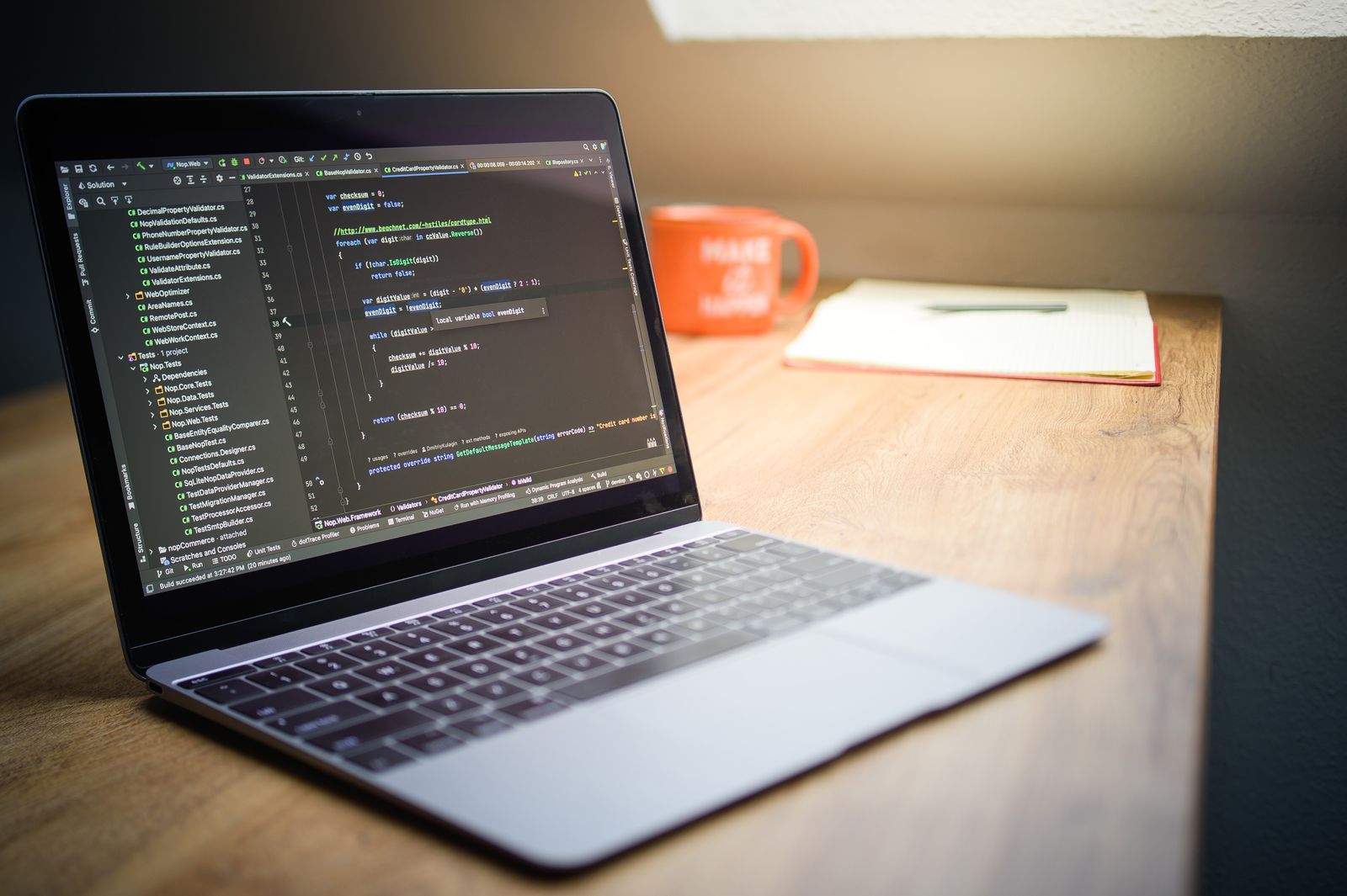 Laptop on a desk showing website code in a modern workspace