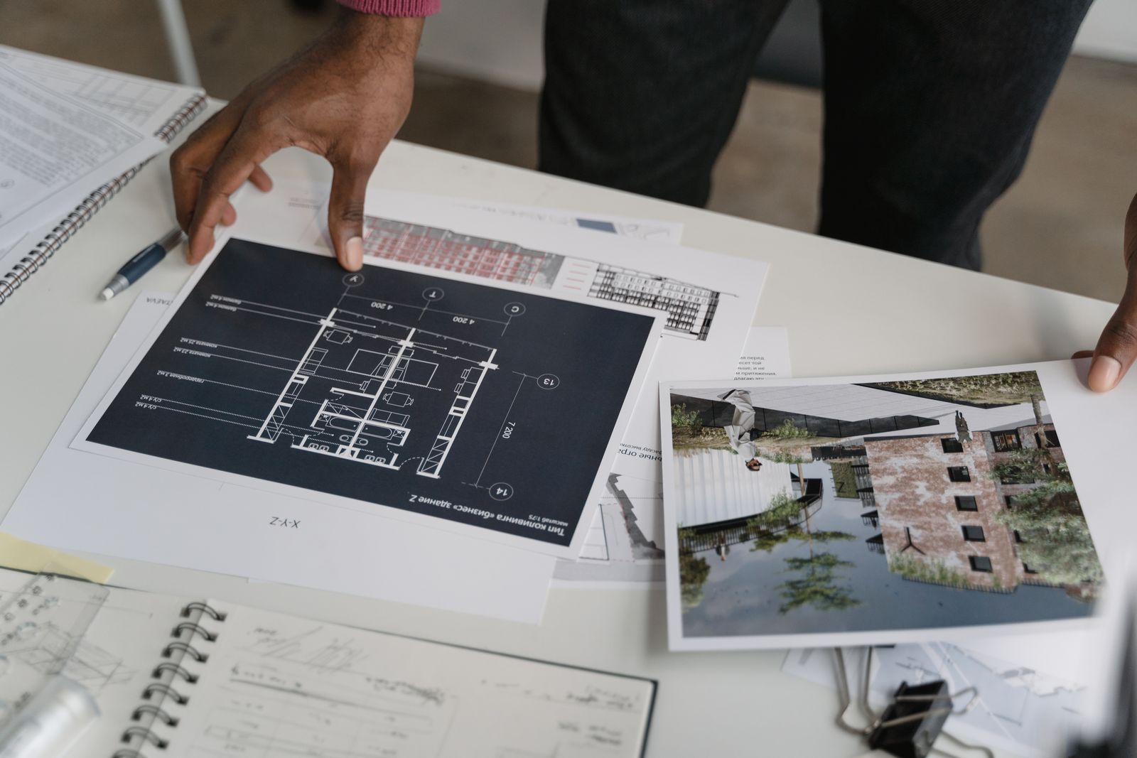 Professionals reviewing architectural project plans and site photographs