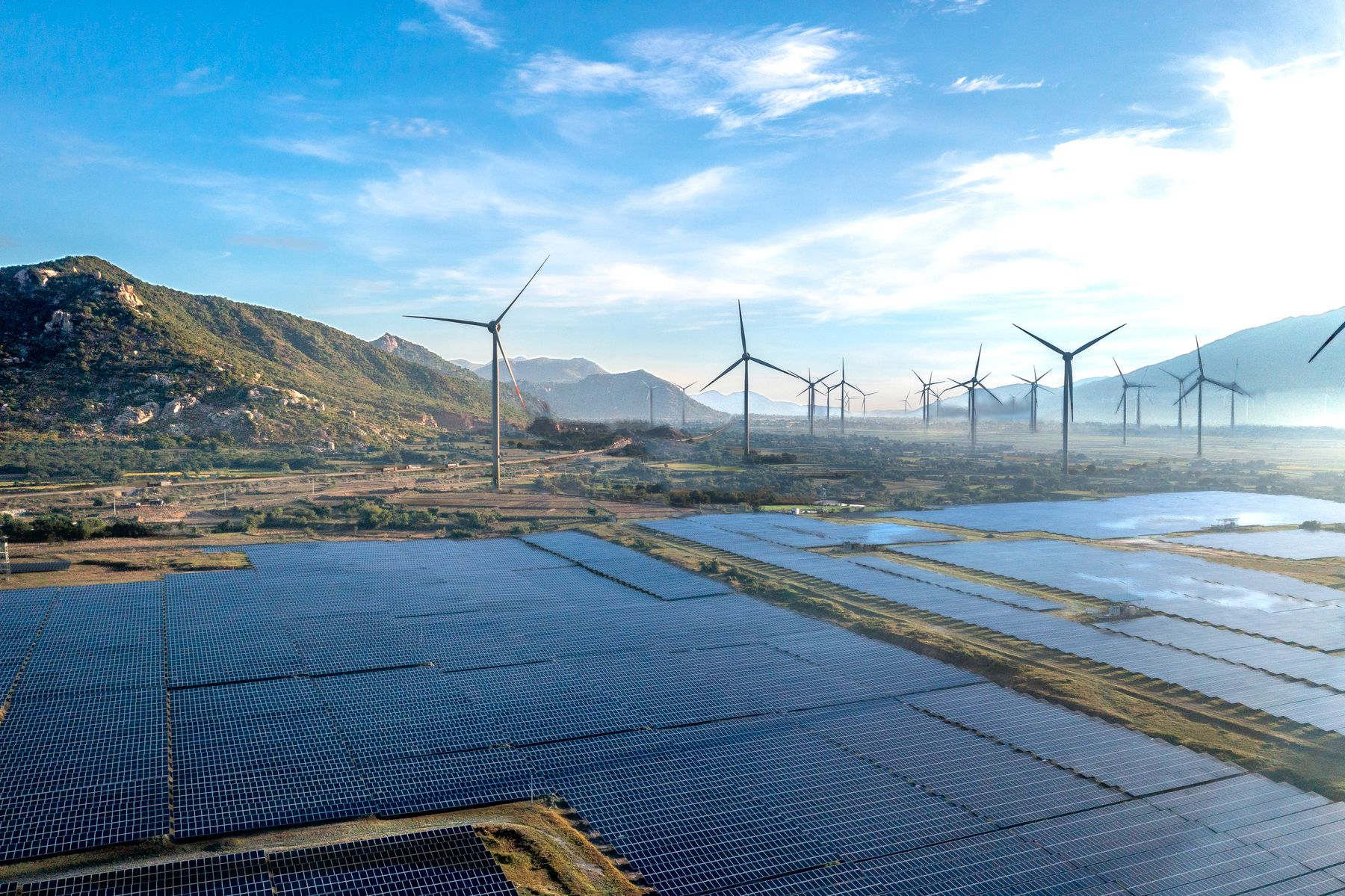 Wind turbines above a large solar farm